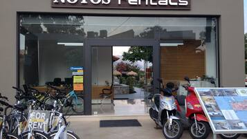 En udlejningsbutik ved navn "NOTOS rentals" med cykler og scootere til udlejning.