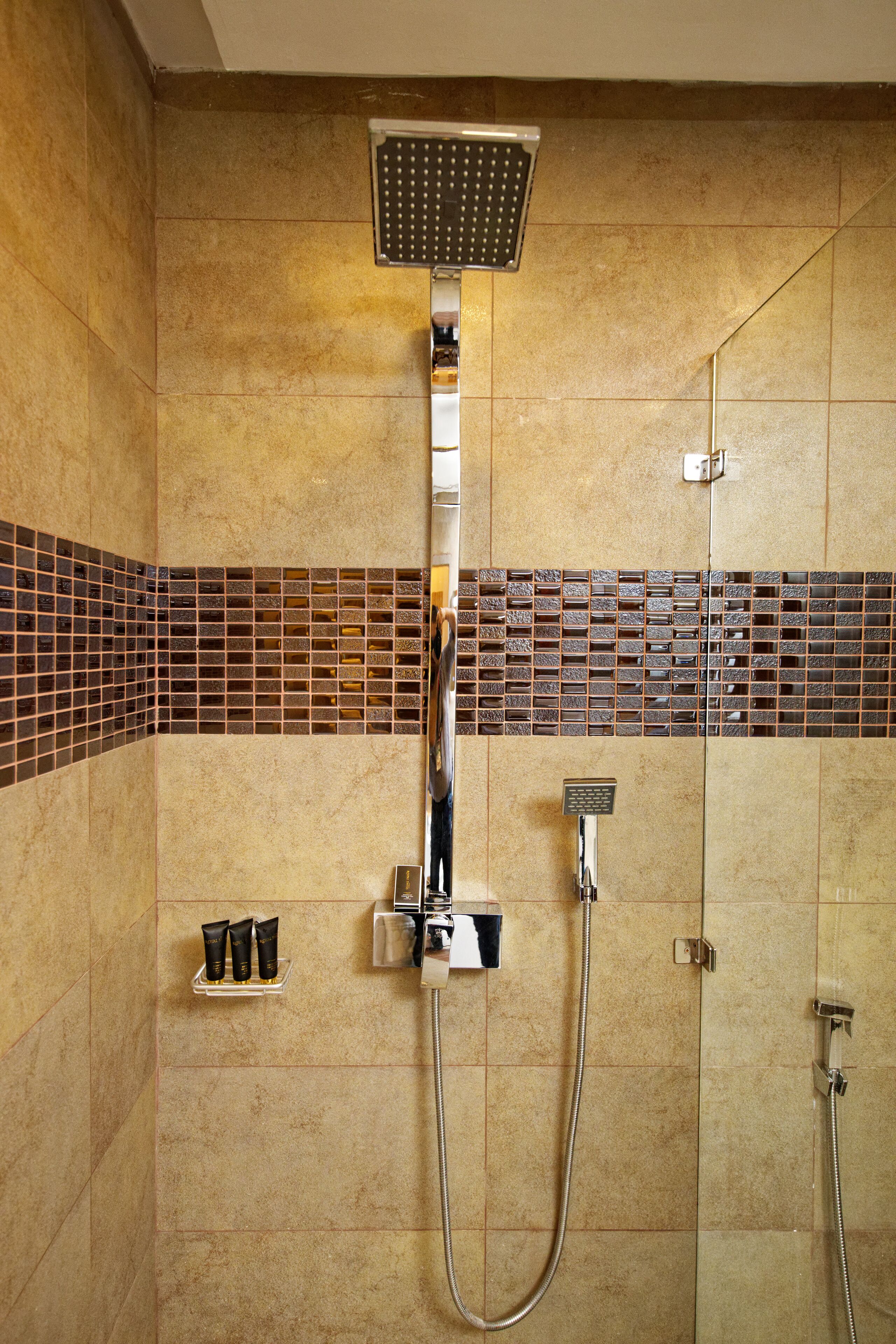 A shower with a rain showerhead, handheld showerhead, and a handheld faucet.