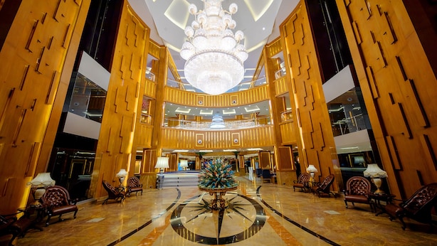 A grand lobby with a large chandelier, a central decorative fountain, and luxurious seating areas. - Royal Swiss Lahore (Lahore)