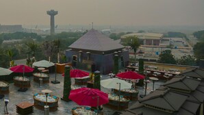 A rooftop terrace with outdoor seating, a central gazebo, and a view of the airport in the background. - Royal Swiss Lahore (Lahore)