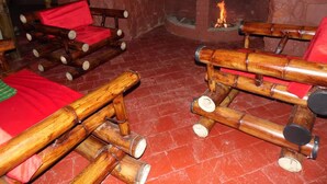 A room with bamboo furniture and a brick fireplace.