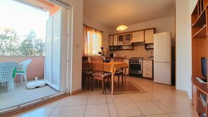 Une cuisine compacte comprenant un coin repas, un réfrigérateur et une table à manger avec des chaises.