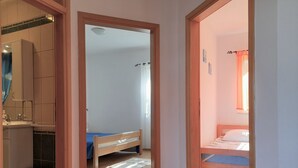 Une chambre comprenant un lit, un petit bureau et une salle de bain avec un lavabo et un miroir.