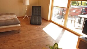 A room with a bed, a chair, a lamp, and a view of the outside. - Apartment for a perfect holiday with the family (Greifswald)