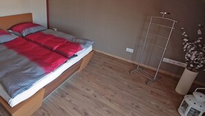 A single bed with a wooden headboard in a room with wooden flooring. - Apartment for a perfect holiday with the family (Greifswald)