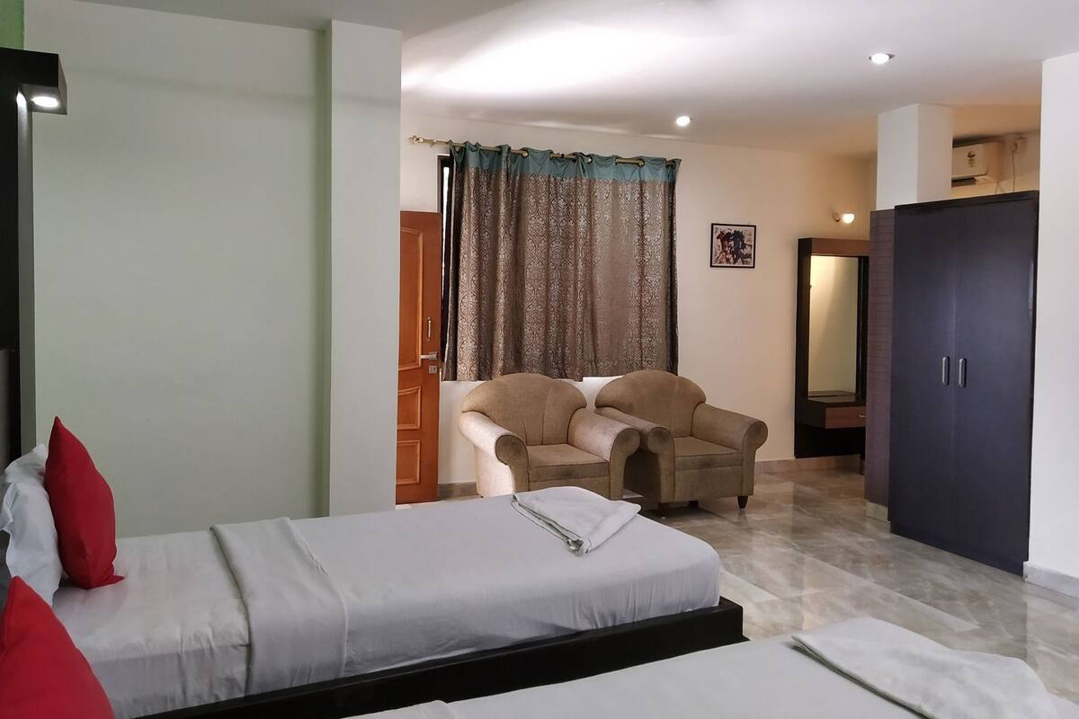 Quarto com cama, cadeira, guarda-roupa e porta para outro cômodo.