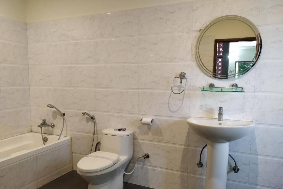 Casa de banho com banheira, sanita e lavatório, tudo com equipamentos modernos.