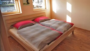 A double bed with a wooden frame and a headboard, two pillows, and a bedside table. - Perfectly equipped apartment1 (Greifswald)