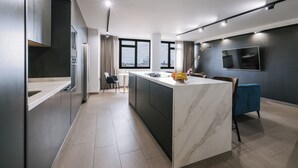 Een moderne keuken met een marmeren eiland, donkere kastjes en uitzicht over de stad.