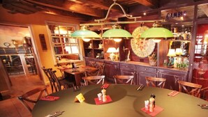 A restaurant with a wooden interior, a round table with chairs, and a bar area with a sign reading "GAMBLE". - Apartment for a maximum of 5 persons (Greifswald)