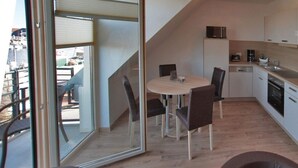 A compact kitchen with a dining area, a microwave, and a coffee maker. - Apartment for a maximum of 5 persons (Greifswald)
