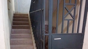 A staircase with metal railings and a door at the bottom. - Sweet Hut Hotel (Marua)