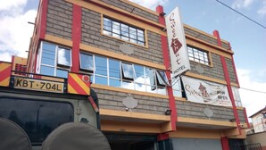 A hotel with a sign reading "Sweet Hotel" and a vehicle with a license plate "KBT-704L" in front. - Sweet Hut Hotel (Marua)