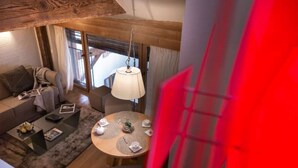 Ein gemütlicher Wohnbereich mit Sofa, Couchtisch und einer Hängelampe.