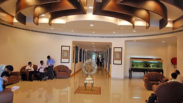 A lobby with a curved ceiling, a grand piano, and a large fish tank. - Hotel Rudra Continental Rudrapur (Kichha)