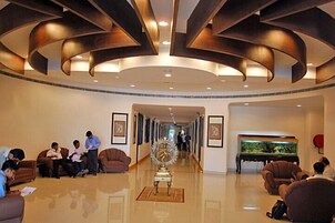 A lobby with a curved ceiling, a grand piano, and a large fish tank.