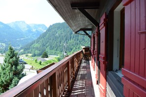 A balcony with a view of a mountainous landscape.