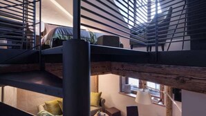 A multi-level interior with a staircase, a dining area, and a seating space. - Lodges - apartments full (Annecy)