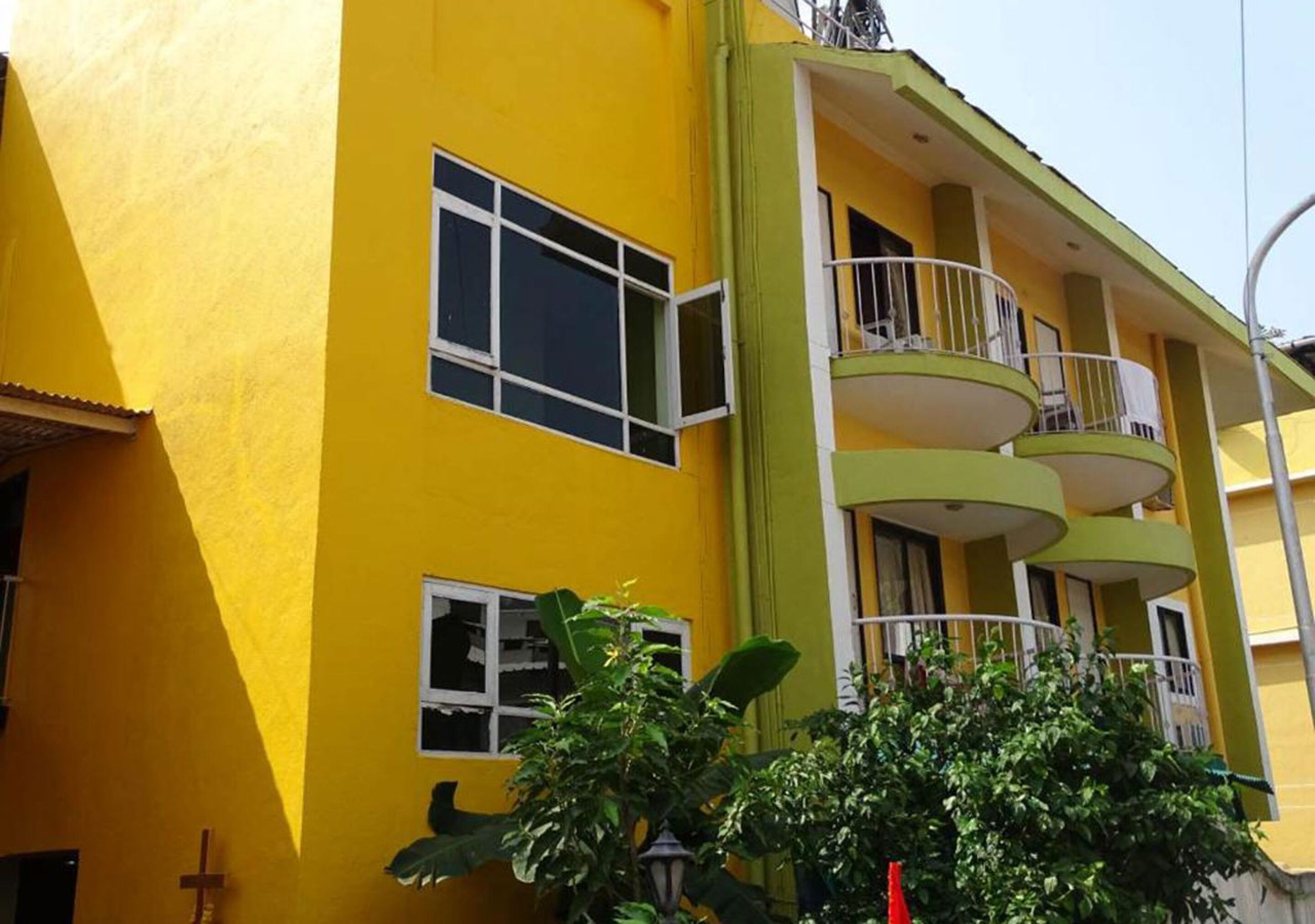 Un edificio amarillo con varios balcones y ventanas.