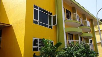 Un edificio amarillo con varios balcones y ventanas.