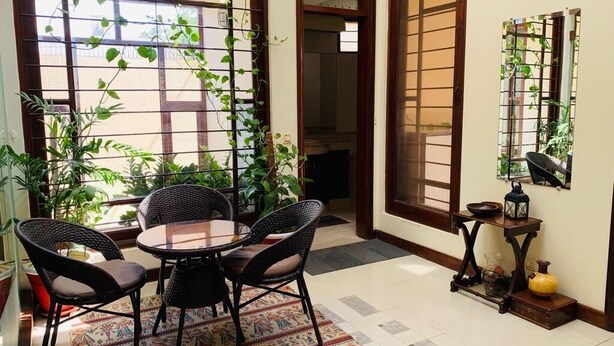 Une pièce dotée d’une porte coulissante de style japonais traditionnel, d’une petite table ronde avec des chaises et d’une lanterne décorative posée sur un piédestal en bois.