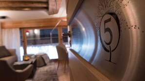 Un interior moderno con un gran número 5 en la pared, un sofá y un comedor con una mesa y sillas.