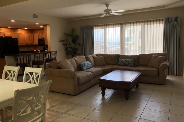 Living room with sectional, flat screen tv, and access to private balcony.