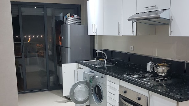 A modern kitchen with a built-in washing machine, a stove, and a sink. - Quiet residence "Perla" (Bousnika)