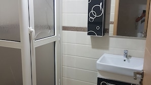 A bathroom with a toilet, a sink, and a shower with frosted glass doors. - Quiet residence "Perla" (Bousnika)