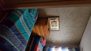 A bedroom with a bed, a wooden cabinet, and a ceiling light fixture. - Quiet residence "Perla" (Bousnika)