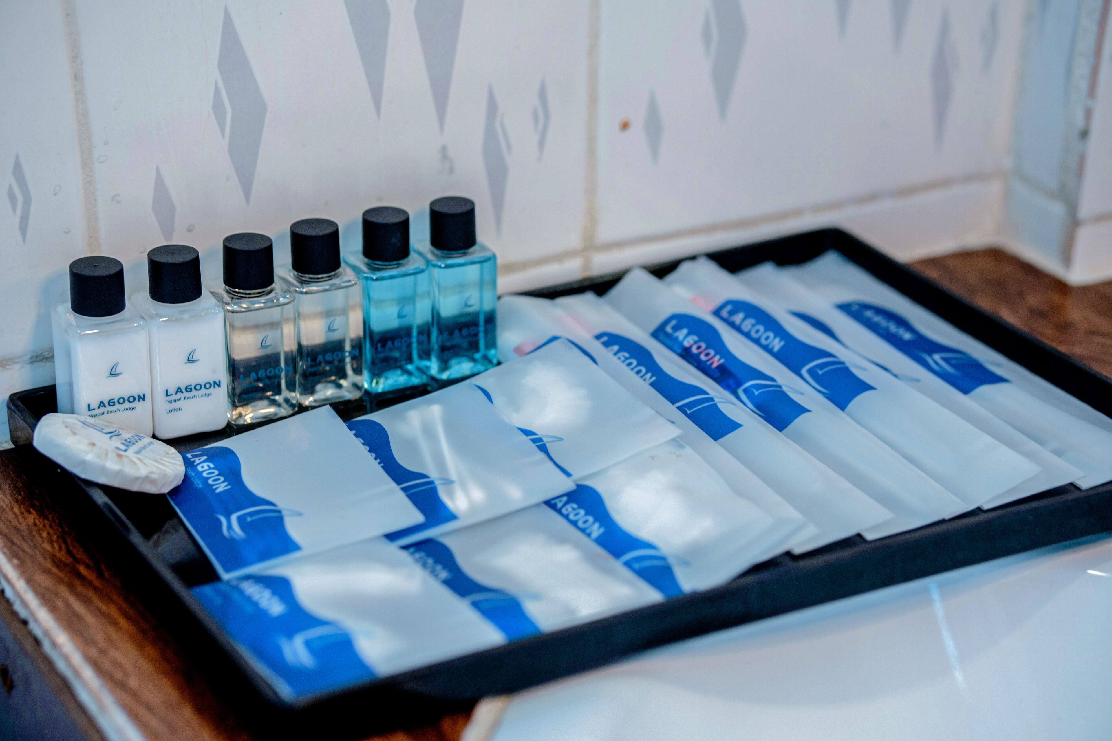 A tray with various toiletries including bottles and packets, likely in a hotel setting.