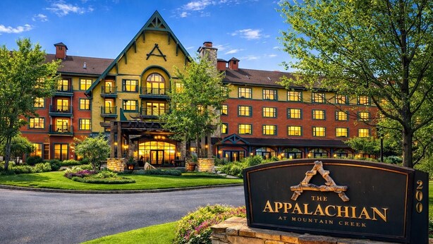 Ein großes, mehrgeschossiges Hotel mit einem markanten Eingang und einem Schild mit der Aufschrift 'The Appalachian at Mountain Creek'.