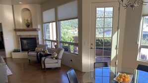 A spacious living room with a fireplace, comfortable seating, a glass dining table with chairs, and large windows offering a view of the outdoors. - Popular West Sedona Home! 3BR 3BA, All Nearby! (Sedona)