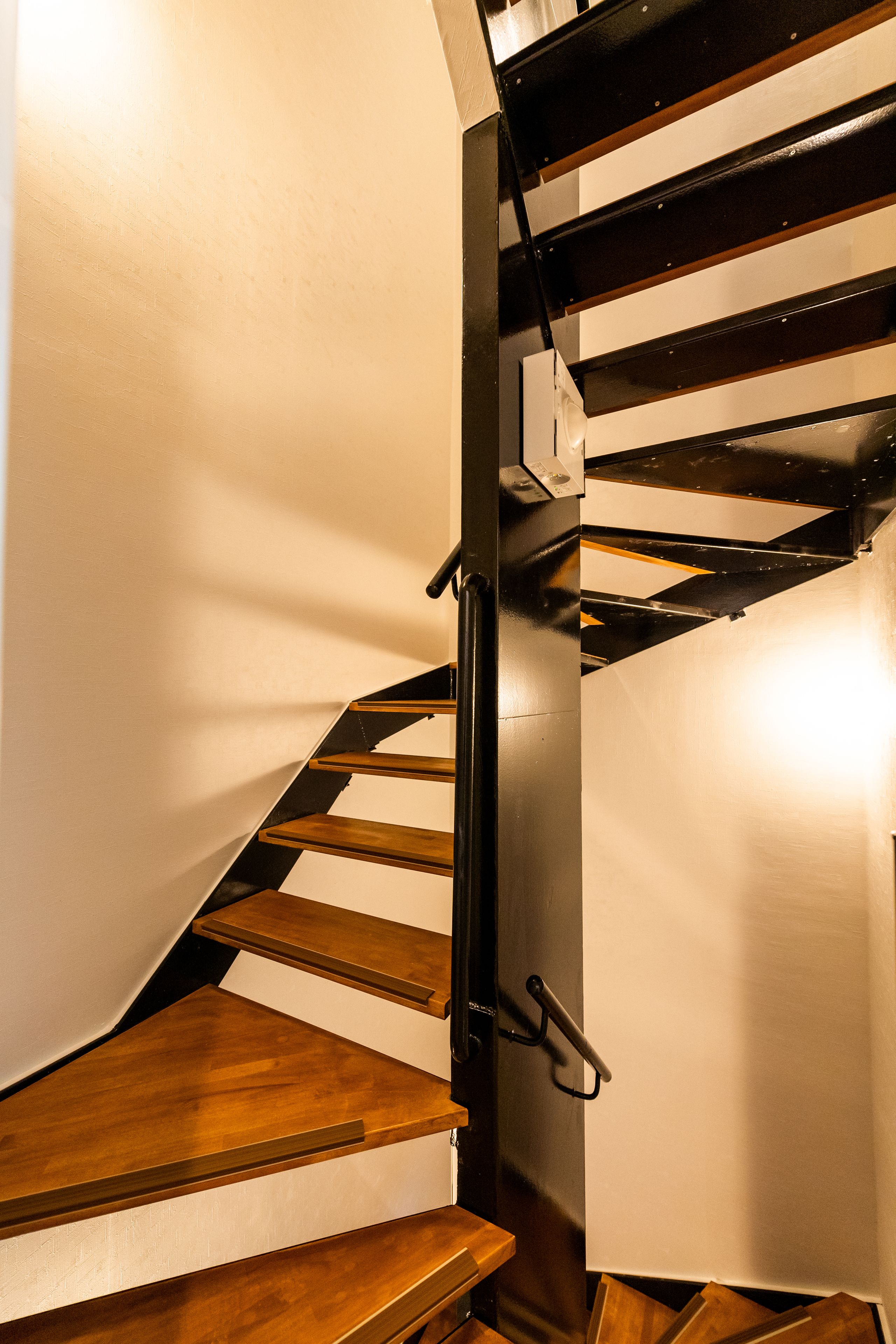 A staircase with wooden steps and a metal handrail.