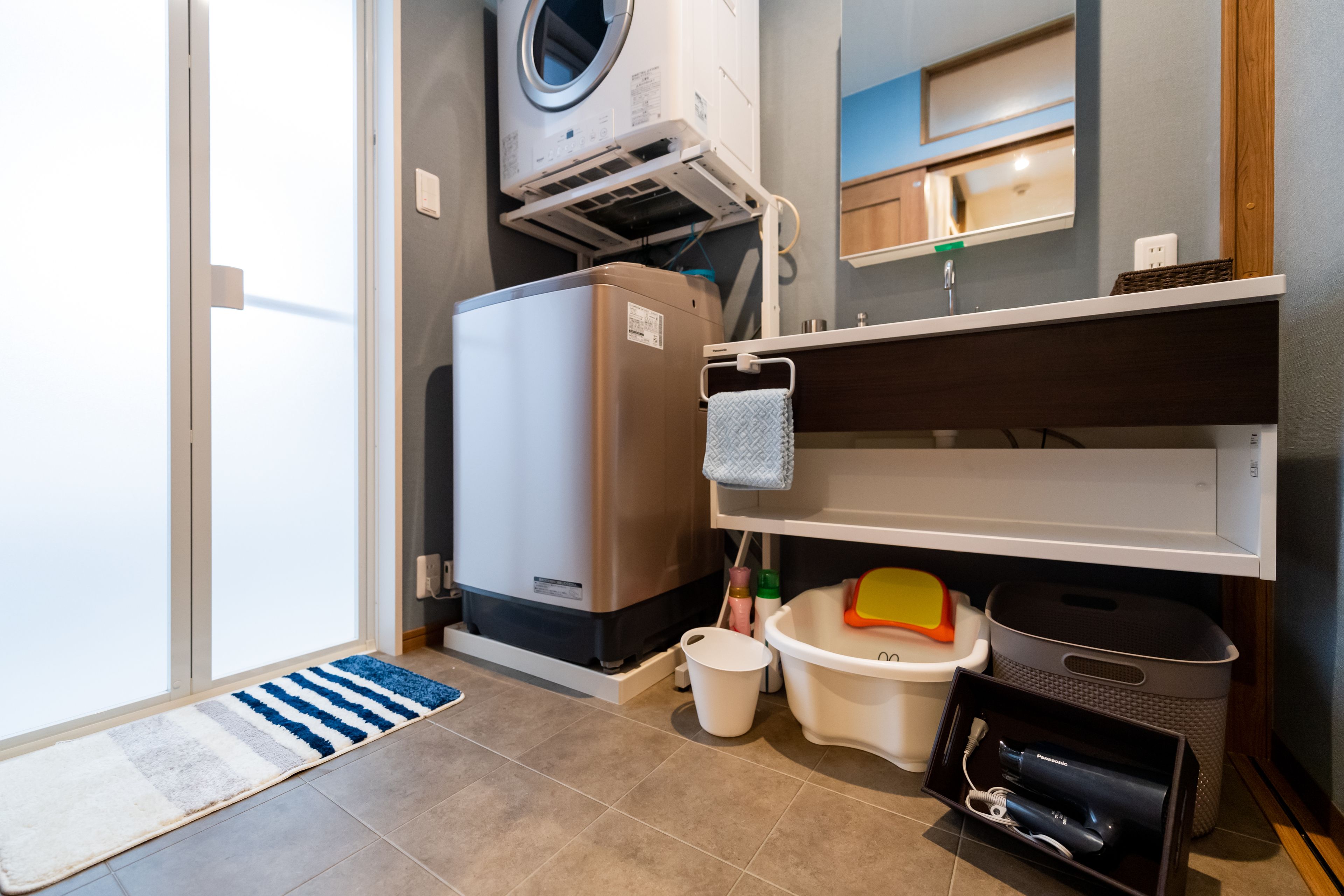 A compact laundry room with a washing machine, dryer, and a small sink area.