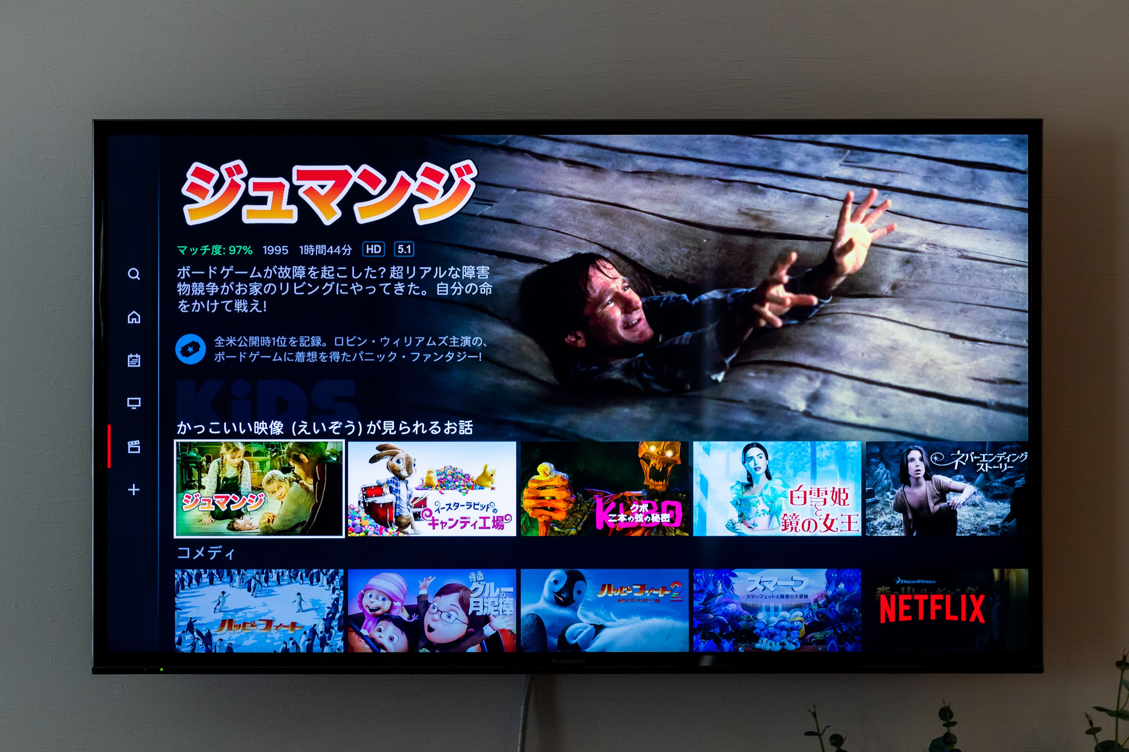 Una pantalla de televisión muestra una interfaz de selección de películas con varios títulos cinematográficos y el logotipo de Netflix.