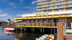 A waterfront hotel with a dock, a speedboat, and several jet skis. - Kanda Zen Apt 3 - pool & walk to the beach! (Pompano Beach)