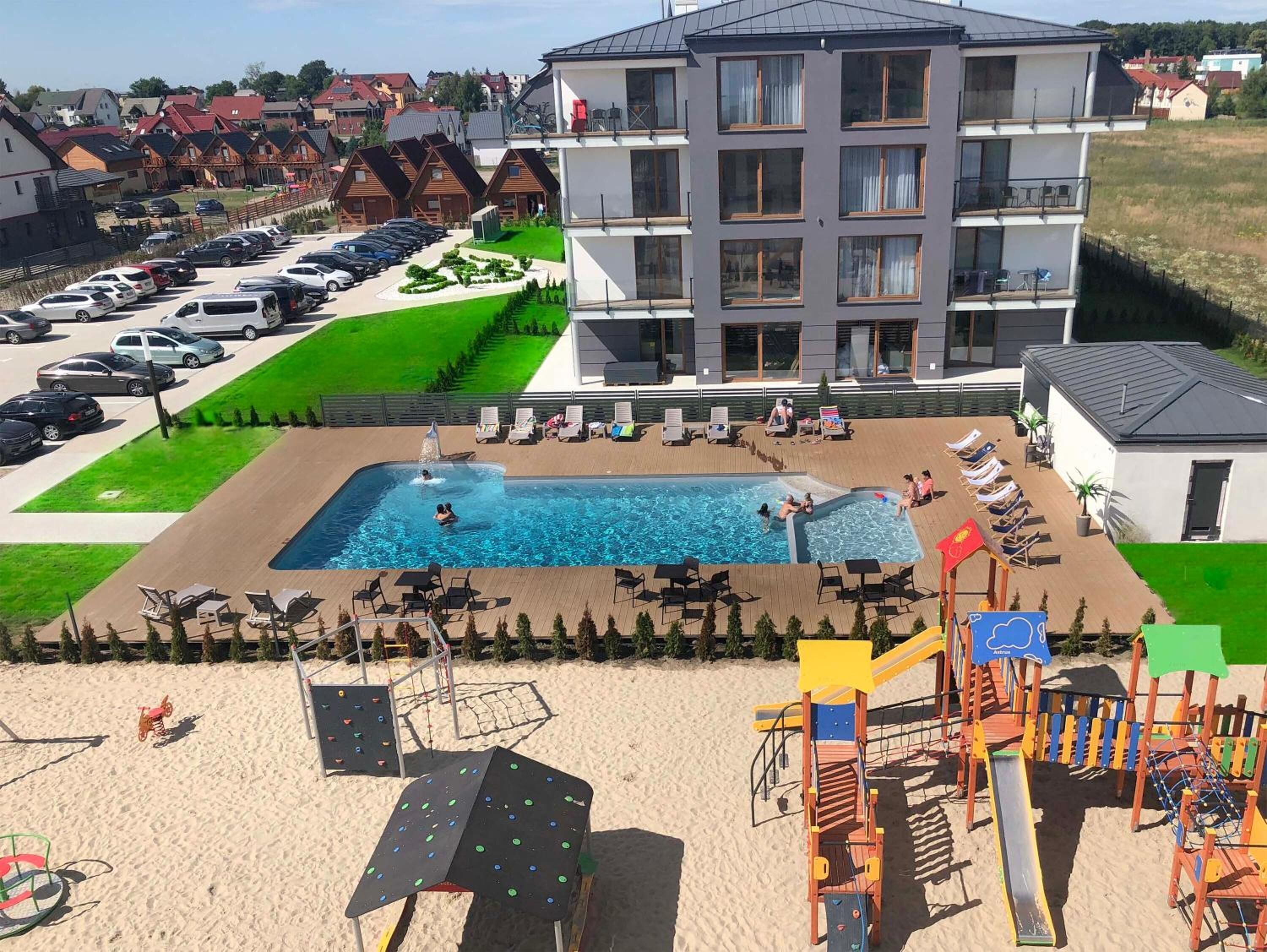 Un hôtel doté d’une piscine, d’un espace extérieur aménagé et d’un terrain de jeux.