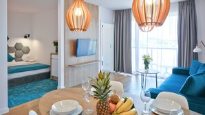 A modern hotel room with a dining area, a sofa, and a TV. - Blu Apartments (Sarbinowo)