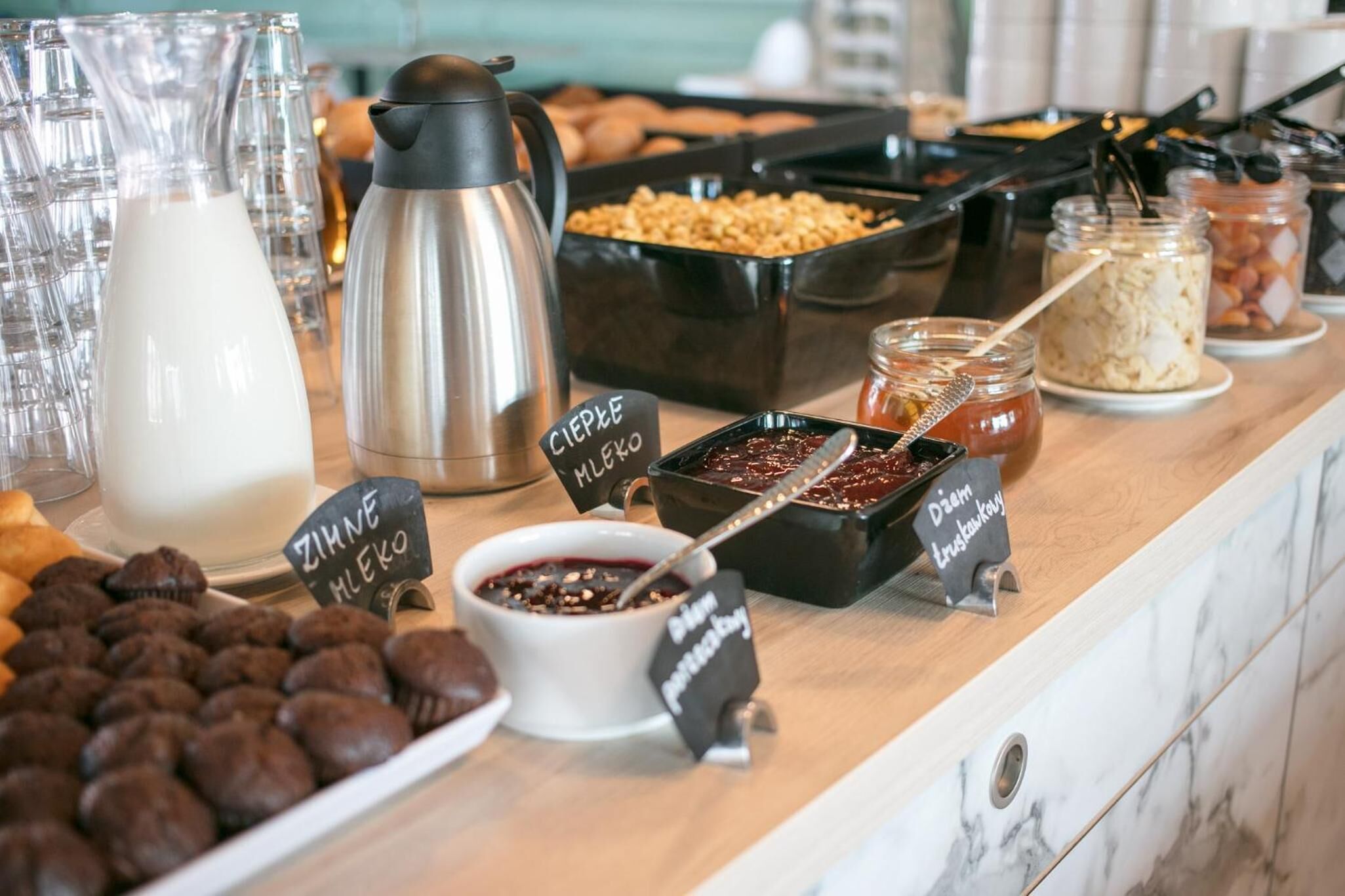 A buffet with various food items including milk, coffee, and desserts.
