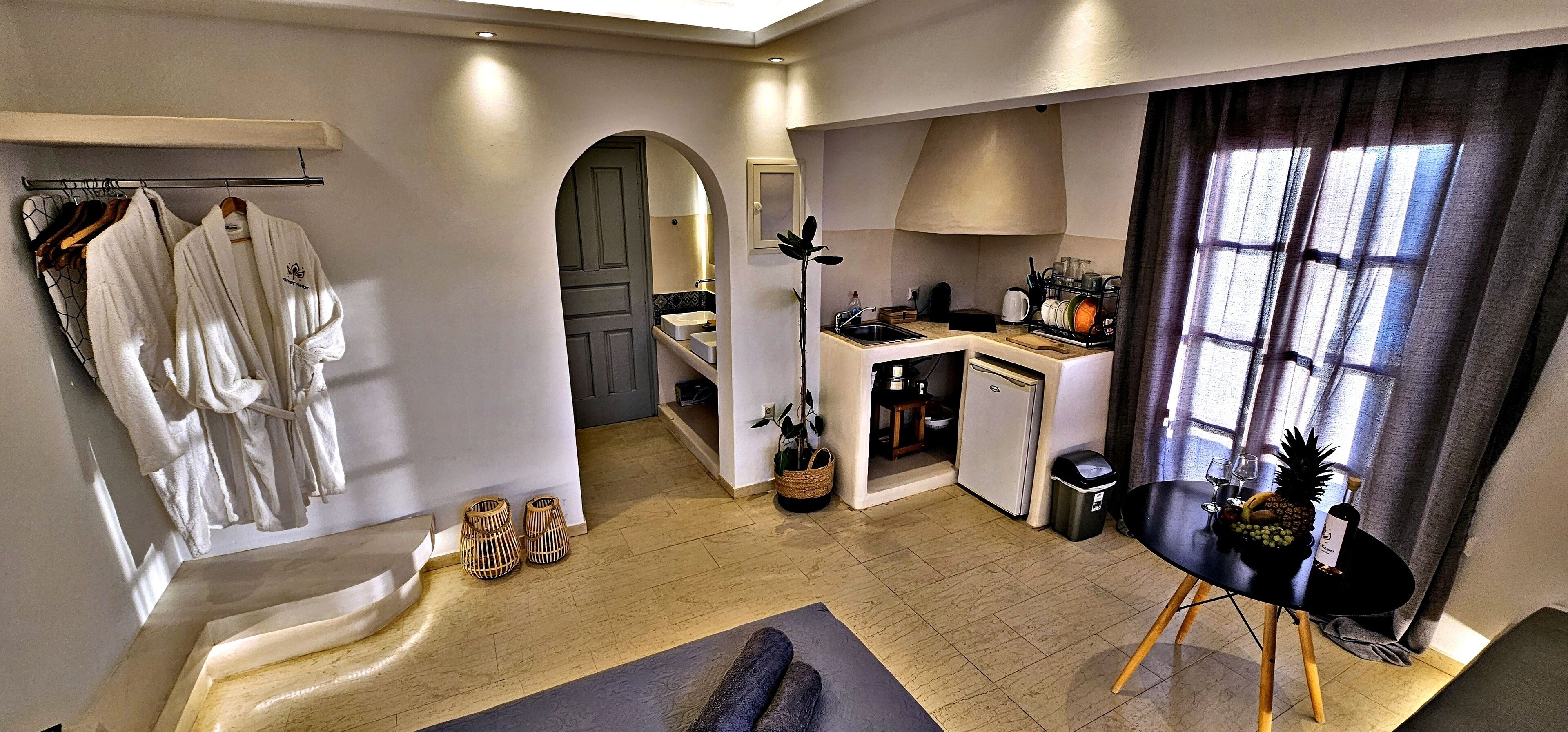 Une chambre d’hôtel équipée d’une kitchenette, d’un coin repas et d’une salle de bain avec un porte-serviettes.