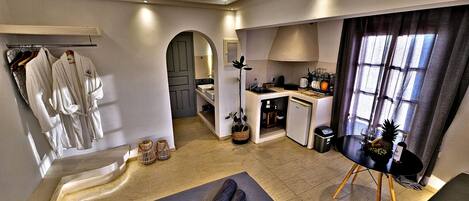 Une chambre d’hôtel équipée d’une kitchenette, d’un coin repas et d’une salle de bain avec un porte-serviettes.