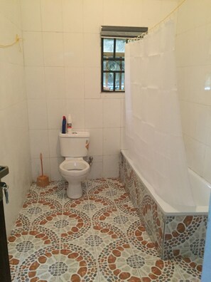 Familie villa | Badkamer | Een bad, pantoffels, handdoeken, shampoo