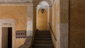 A staircase with a sign reading "PORTIERI" leading to a landing. - A World Aparts - Torre Argentina Apartments (Rome)