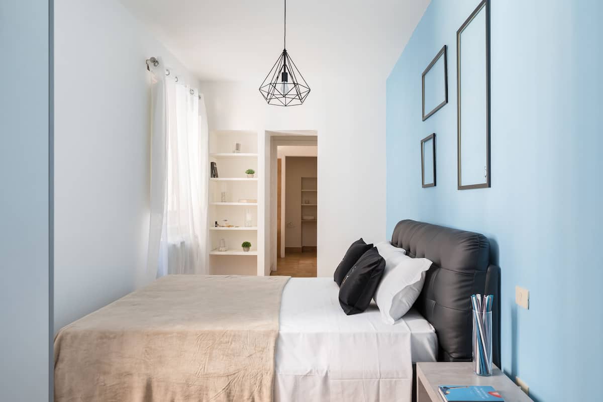 Une chambre à coucher avec un lit, une table de chevet, une lampe et une armoire.