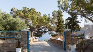 A stone pathway leading to a gate with a view of the sea. - Ferma Hill Apartments (Ierapetra)
