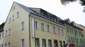 Un edificio de varios pisos con techo plano y numerosas ventanas.