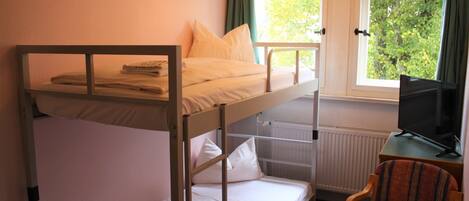 A bunk bed with a television on a small table beside it.