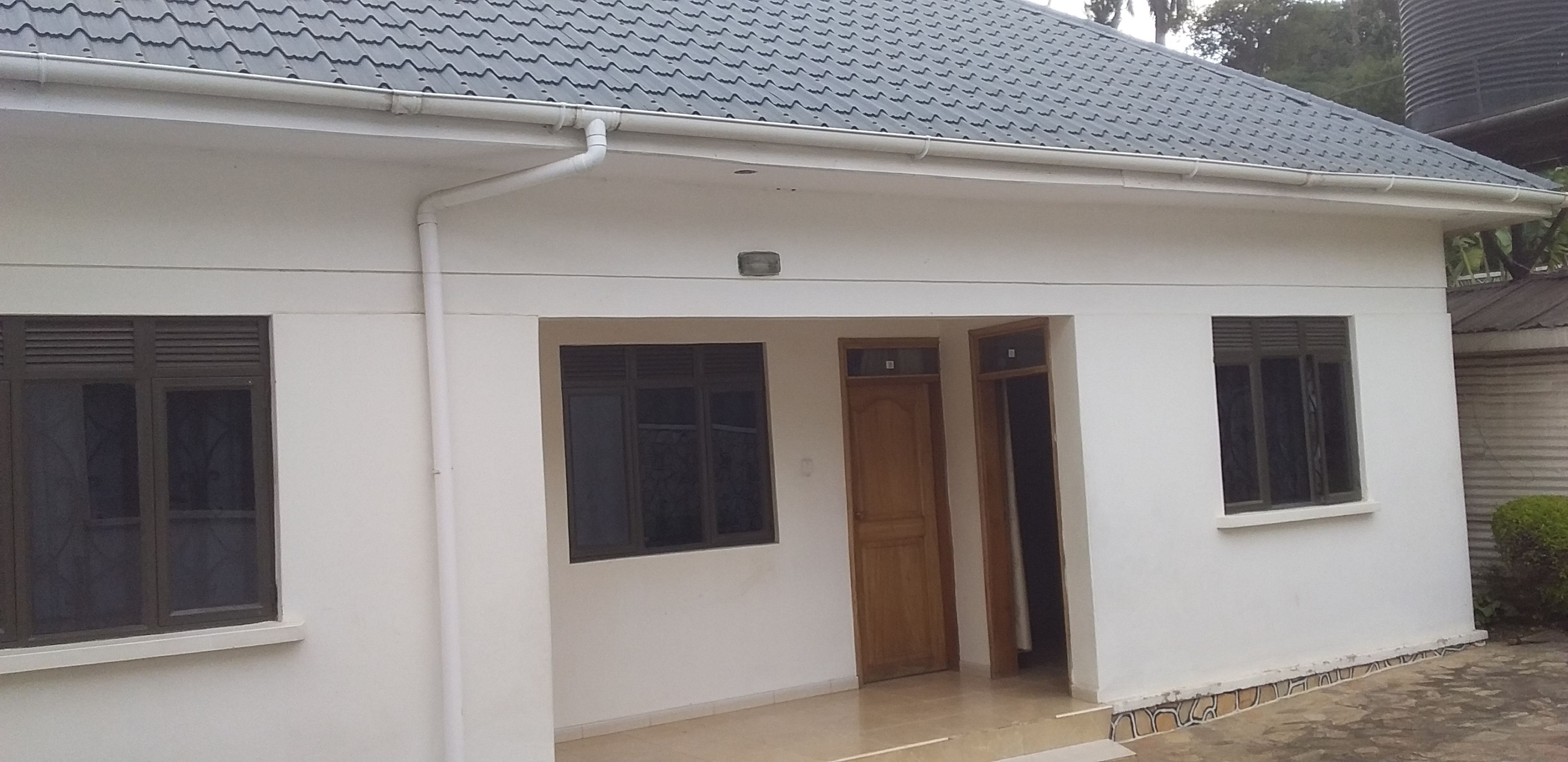 A single-story house with a tiled roof, a front door, and two windows on the ground floor.