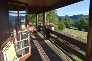 Eine Holzterrasse mit Blick auf eine grüne Landschaft.